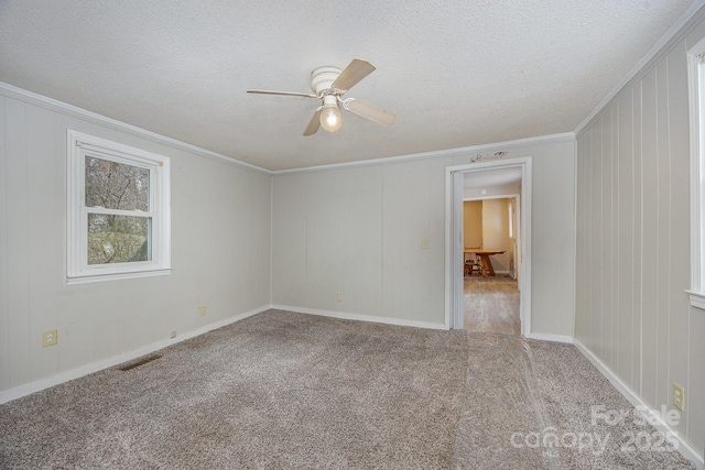 empty room featuring crown molding, light carpet, and a textured ceiling