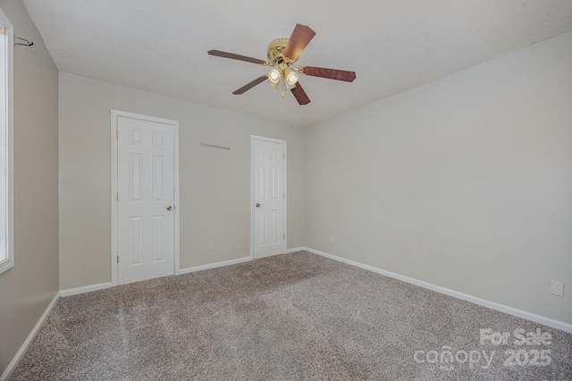 empty room featuring ceiling fan, carpet, and a textured ceiling