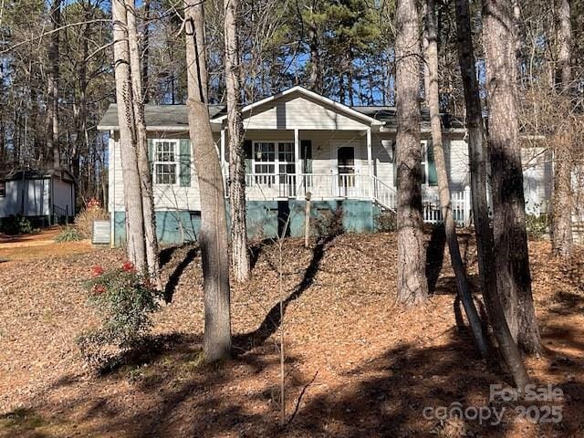 rear view of house featuring covered porch