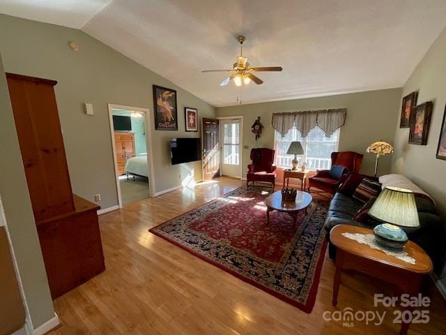 living room featuring lofted ceiling, wood-type flooring, and ceiling fan