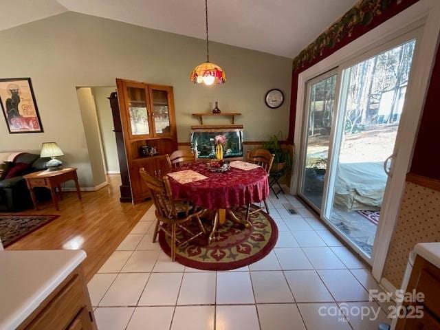 dining area featuring vaulted ceiling and light tile patterned floors