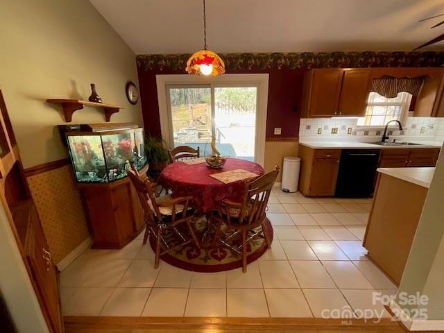 tiled dining area featuring vaulted ceiling and sink