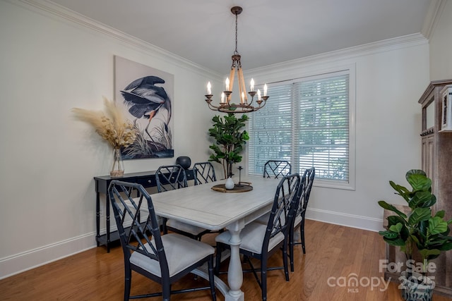 dining room featuring wood-type flooring, ornamental molding, and a notable chandelier