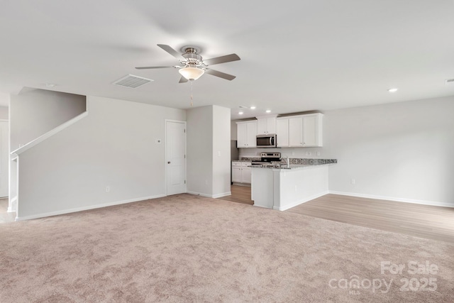 unfurnished living room with light carpet and ceiling fan