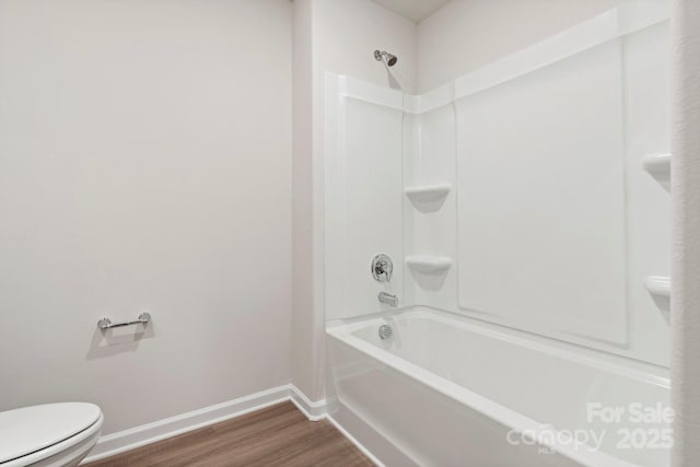 bathroom with toilet, hardwood / wood-style floors, and shower / washtub combination