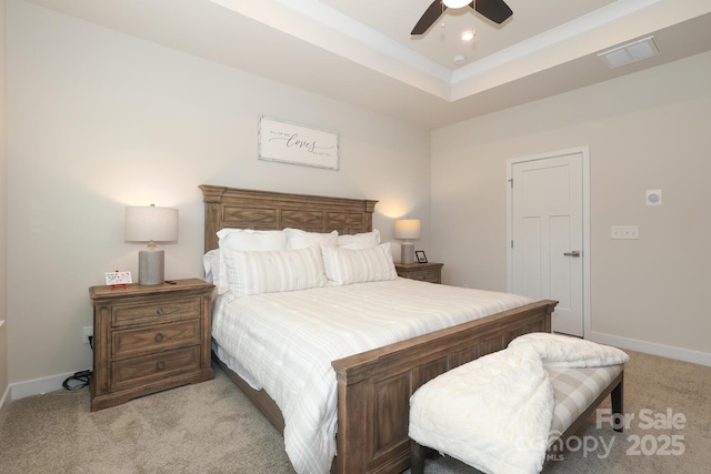 bedroom with light carpet, ceiling fan, and a raised ceiling