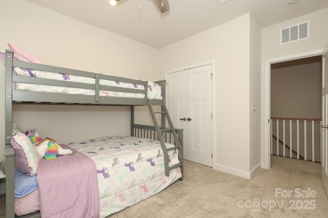 carpeted bedroom with ceiling fan and a closet