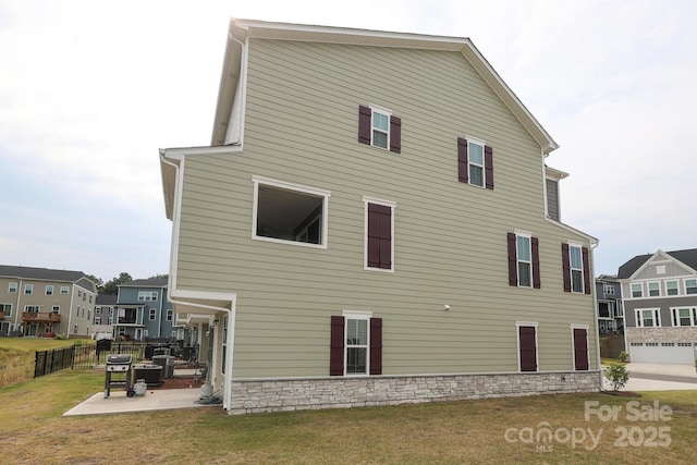 rear view of property featuring a lawn and a patio