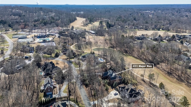 drone / aerial view featuring a wooded view