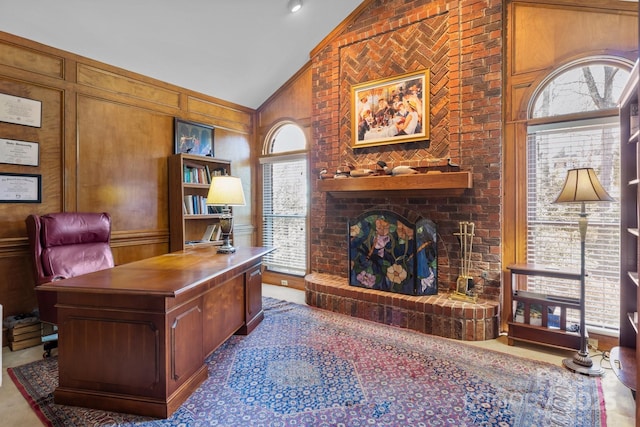 office area featuring a decorative wall, a brick fireplace, and high vaulted ceiling