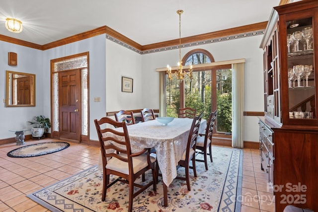 dining area featuring light tile patterned flooring, a notable chandelier, crown molding, and baseboards