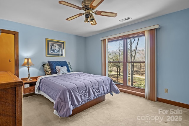 carpeted bedroom featuring visible vents, multiple windows, baseboards, and ceiling fan