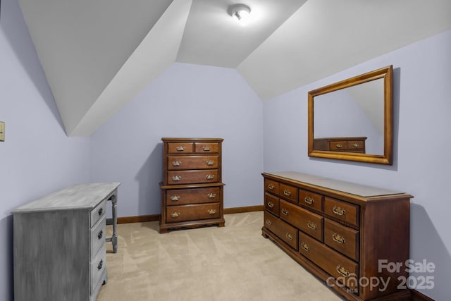 bedroom featuring lofted ceiling, light colored carpet, and baseboards