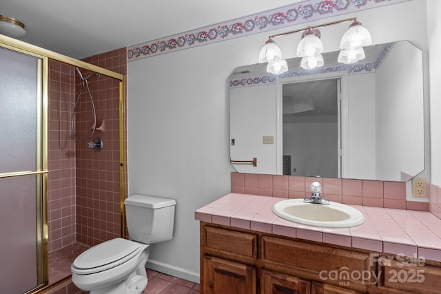 bathroom with vanity, toilet, baseboards, and a stall shower