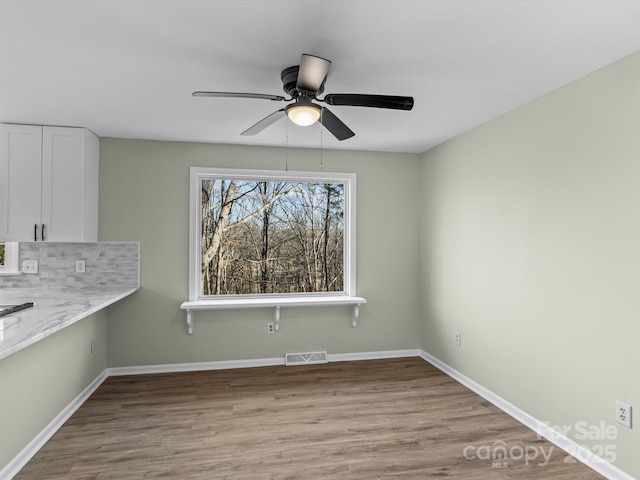 unfurnished dining area featuring ceiling fan and light hardwood / wood-style flooring