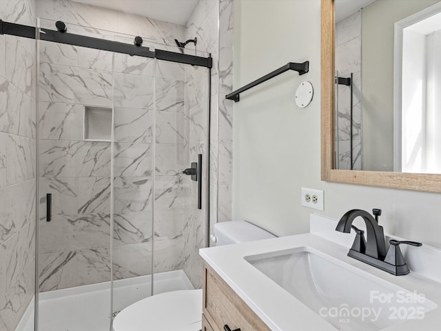 bathroom featuring toilet, an enclosed shower, and vanity