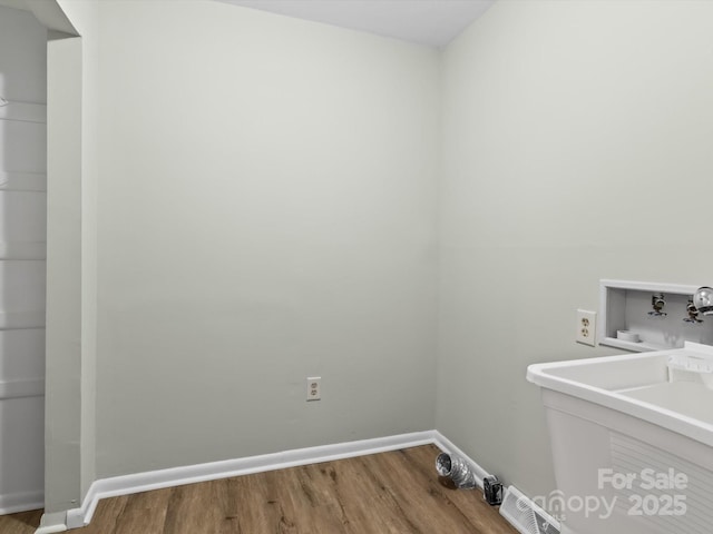 washroom featuring sink, wood-type flooring, and hookup for a washing machine