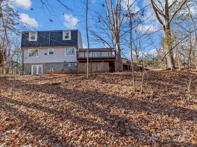 rear view of property featuring a deck and central AC