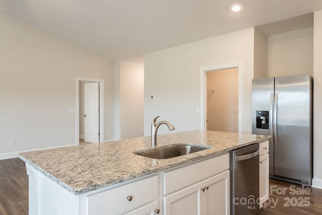 kitchen featuring sink, a kitchen island with sink, stainless steel appliances, white cabinets, and light stone counters