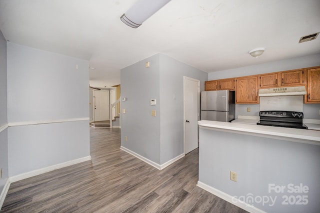 kitchen featuring stainless steel fridge, black electric range, and light hardwood / wood-style flooring