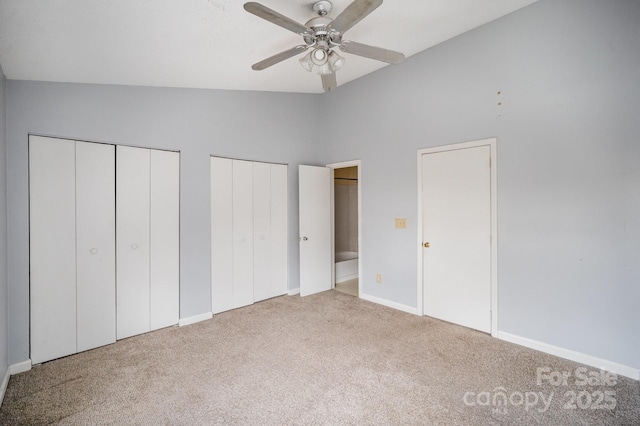 unfurnished bedroom with two closets, high vaulted ceiling, ceiling fan, and carpet