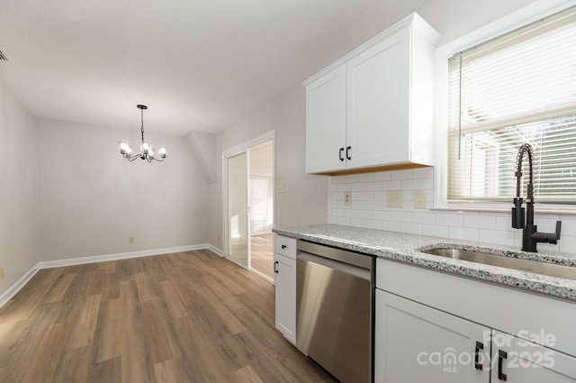 kitchen featuring light stone countertops, white cabinets, dishwasher, sink, and backsplash