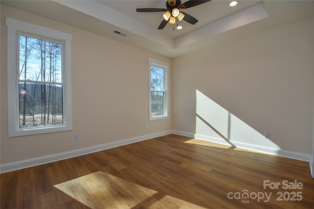 spare room featuring ceiling fan, hardwood / wood-style floors, and a tray ceiling