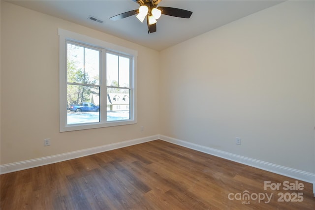 unfurnished room featuring dark wood-type flooring and ceiling fan