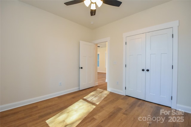 unfurnished bedroom with ceiling fan, a closet, and hardwood / wood-style floors