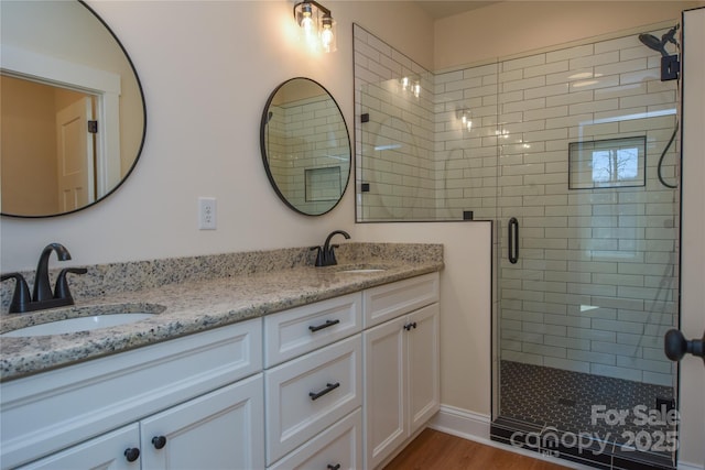 bathroom with vanity, a shower with door, and hardwood / wood-style floors