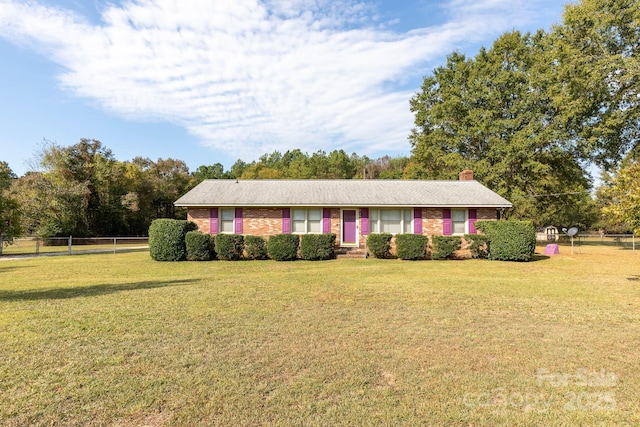 ranch-style house featuring a front yard, brick siding, and fence