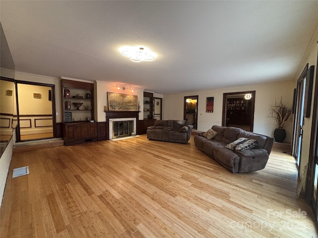 living room featuring a textured ceiling and light wood-type flooring