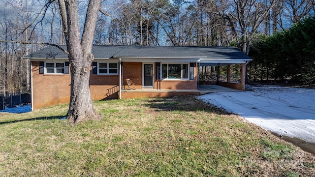 ranch-style home with a front lawn, a porch, and a carport