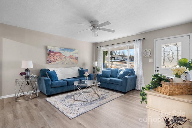 living room with ceiling fan, a textured ceiling, and hardwood / wood-style floors