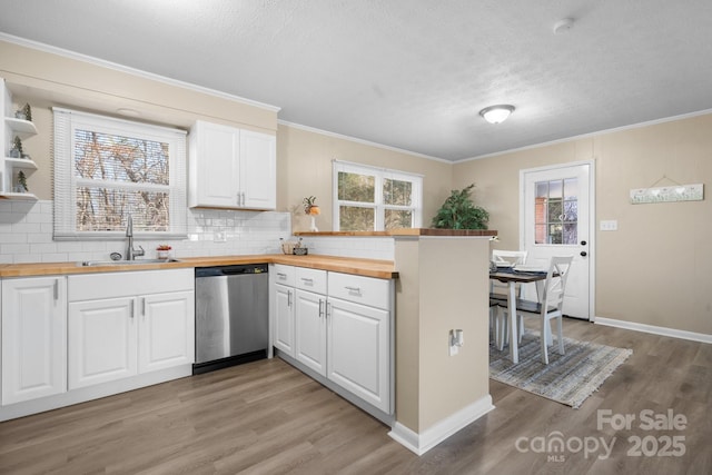 kitchen featuring sink, white cabinets, stainless steel dishwasher, and butcher block counters