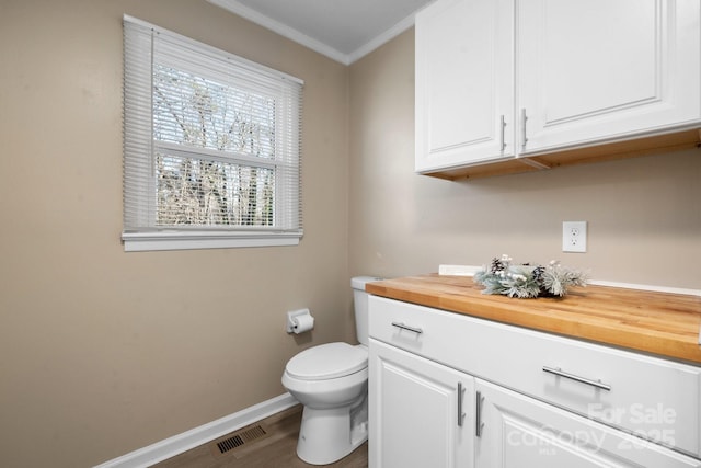 bathroom with toilet, vanity, ornamental molding, and hardwood / wood-style floors