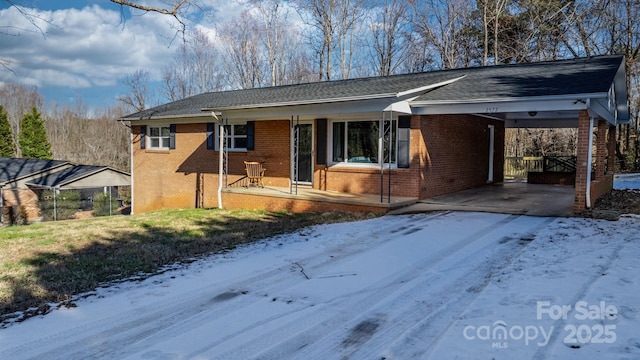 ranch-style home with covered porch and a carport