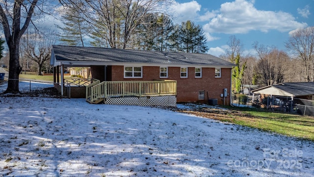 snow covered house featuring a deck and central air condition unit