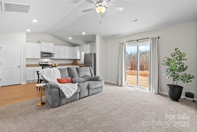 living room featuring light carpet, vaulted ceiling, and ceiling fan