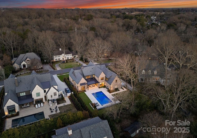 aerial view at dusk with a residential view and a view of trees