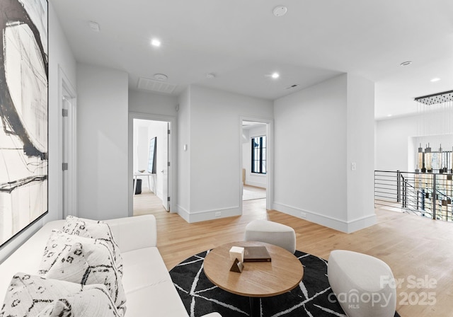 living area featuring light wood-style floors, recessed lighting, and baseboards