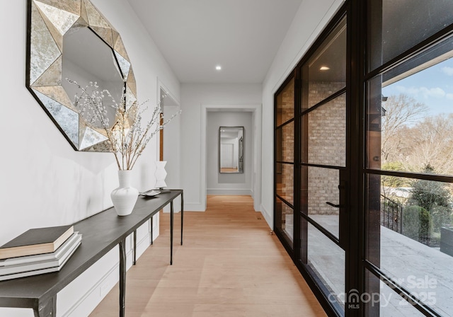 hall featuring baseboards and light wood-style floors