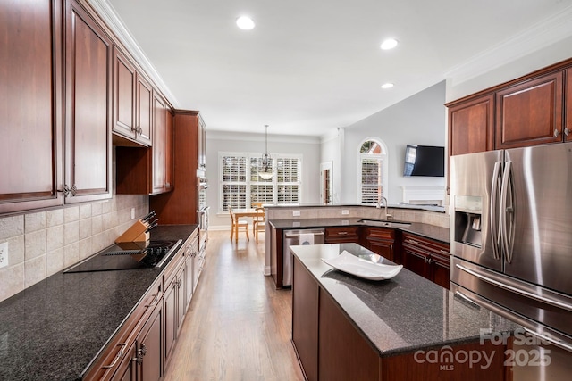 kitchen with sink, backsplash, appliances with stainless steel finishes, and a center island