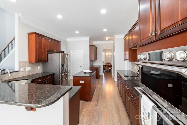 kitchen with a kitchen island, stainless steel refrigerator with ice dispenser, sink, kitchen peninsula, and a breakfast bar area