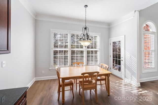 dining room with dark wood-type flooring and crown molding