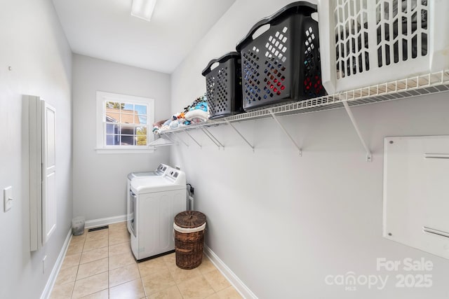 laundry area with washing machine and dryer and light tile patterned flooring