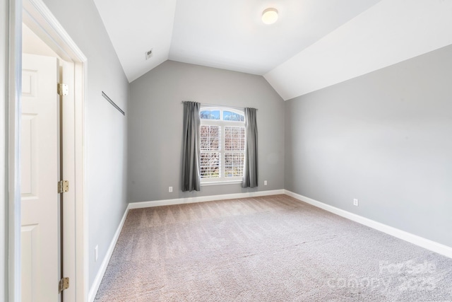 unfurnished bedroom featuring vaulted ceiling and carpet