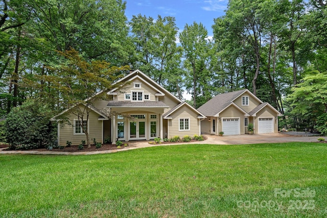 craftsman-style house featuring french doors, a garage, and a front yard