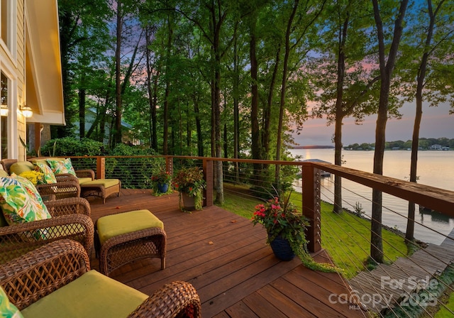 deck at dusk featuring an outdoor living space and a water view