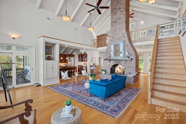 living room with high vaulted ceiling, ceiling fan, a brick fireplace, and plenty of natural light